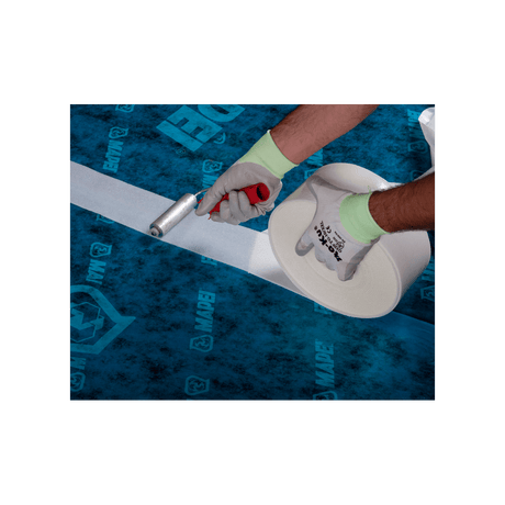 Hands with gloves applying adhesive tape to a seam on a blue floor with logos.