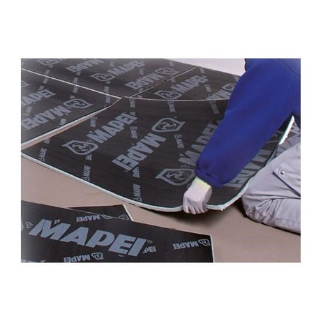 Person in blue and white laying out a branded underlayment on the floor.